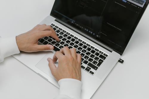 Image of hands typing on a laptop computer
