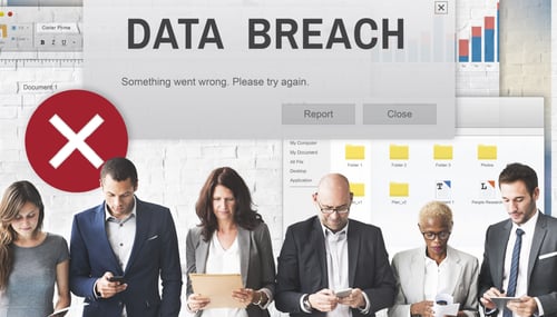 Group of business people looking down and checking their devices during data breach