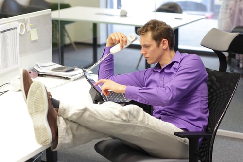 Young professional male with feet up on desk in ofice