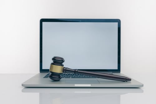 Laptop computer with courtroom gavel resting on keyboard
