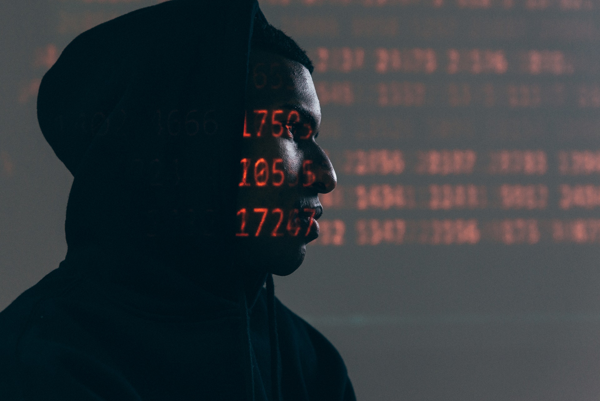 Image of hacker with superimposed digital text
