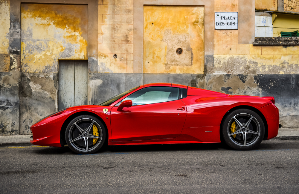 Ferrari sports car parked next to old Spanish bulding